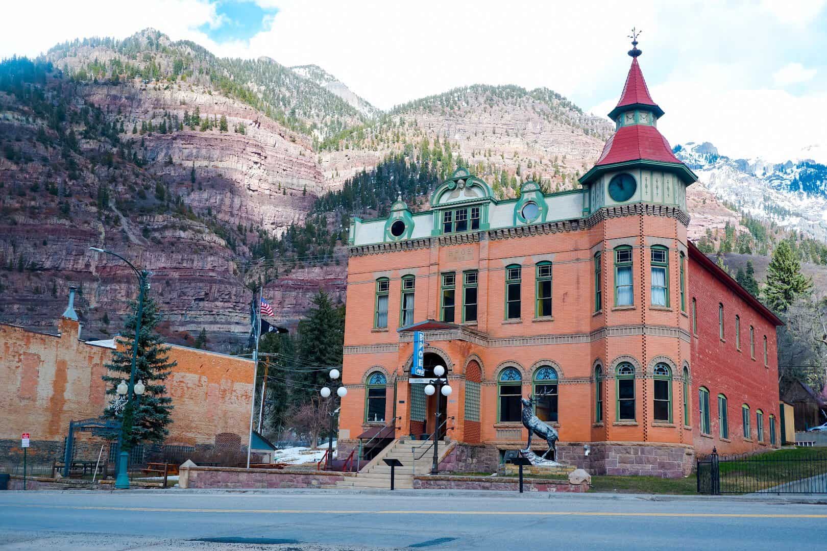 A historic building below the red canyon walls of Ouray at the north end of the Million Dollar Highway in Colorado
