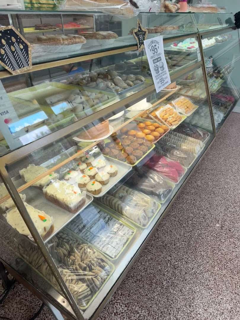 A display case of cupcakes and pastries at Moeller's Bakery in Houston