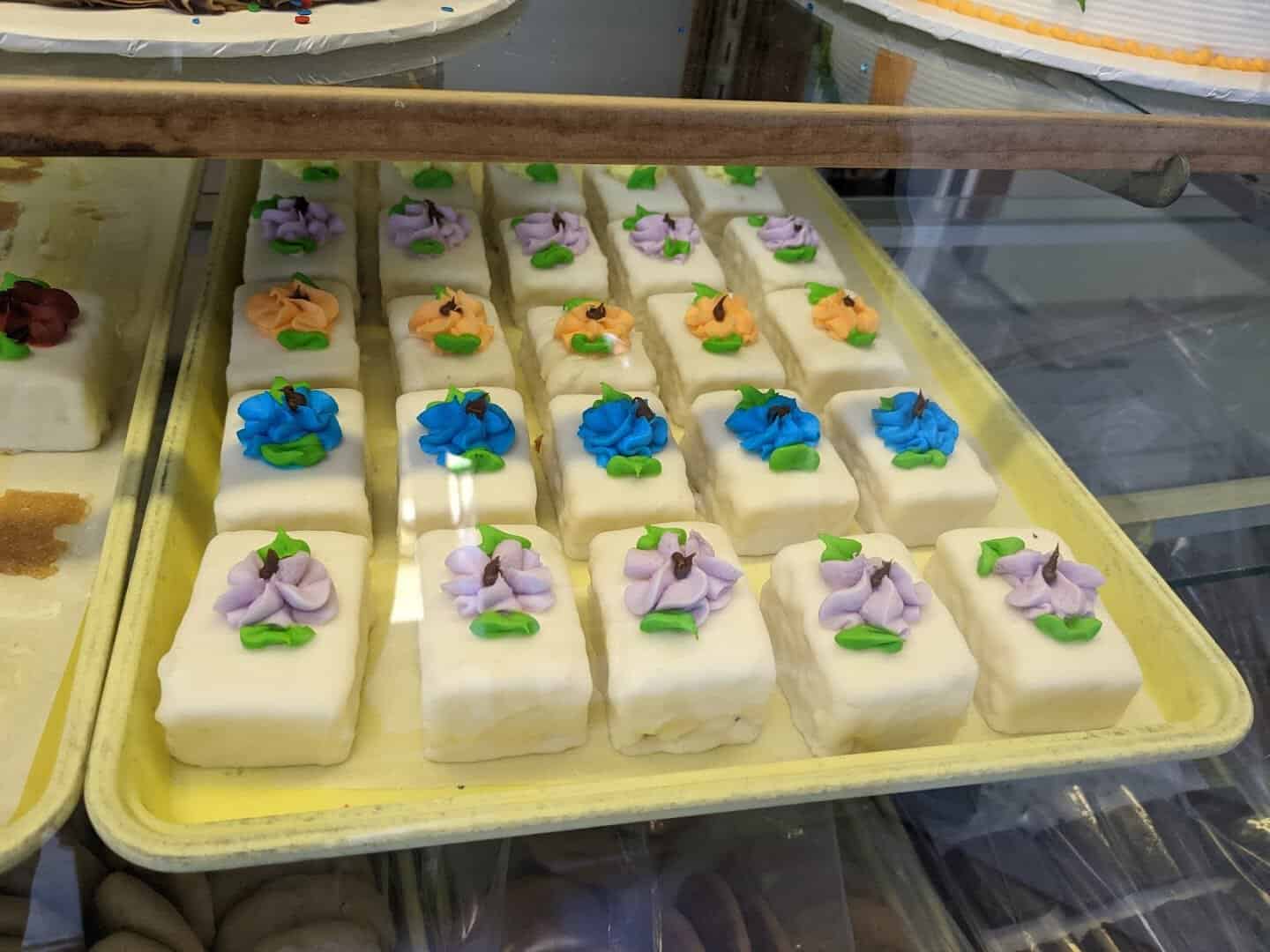 White petit fours topped with icing flowers at Moeller's Bakery in Houston