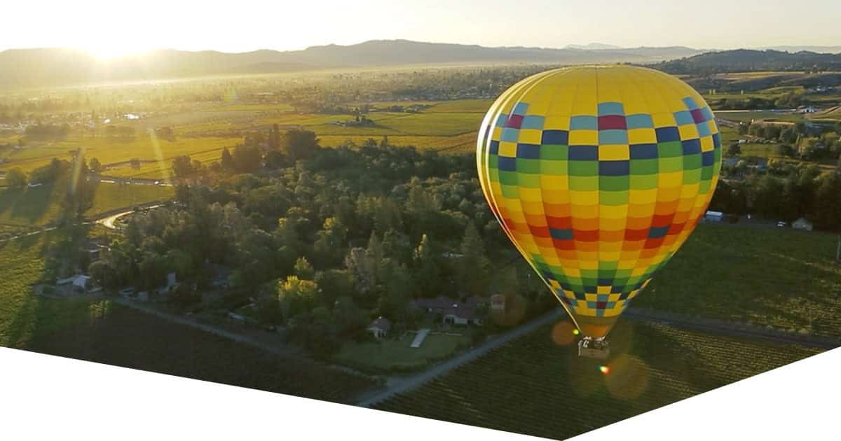 Hot air balloons drifting over Napa Valley vineyards at sunrise, Napa Valley, California