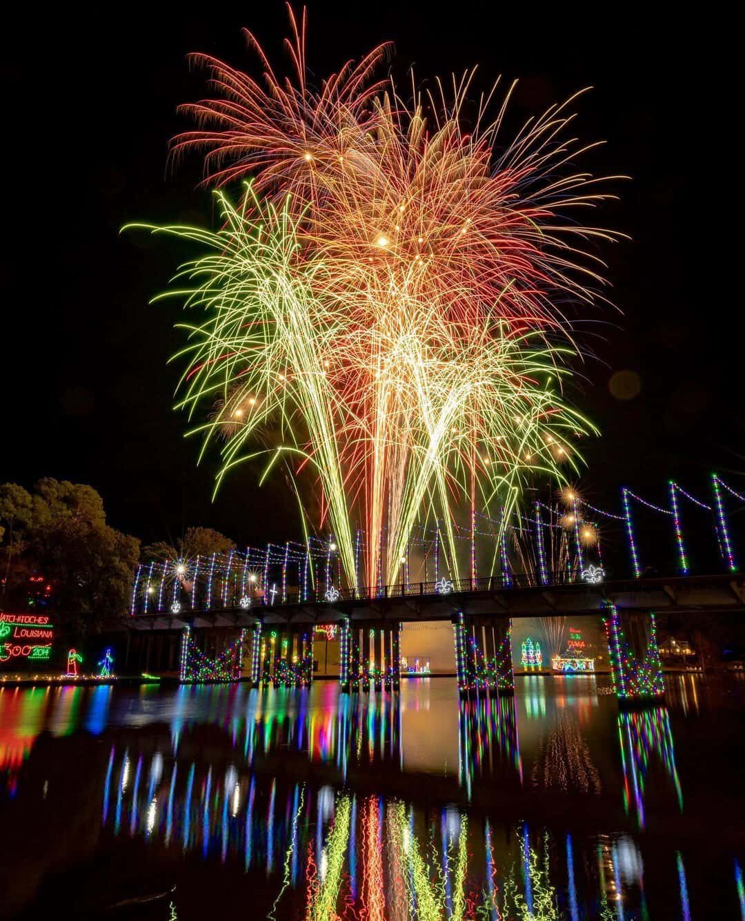 Colored holiday lights and fireworks reflected on the river during the Natchitoches Christmas Festival, Louisiana