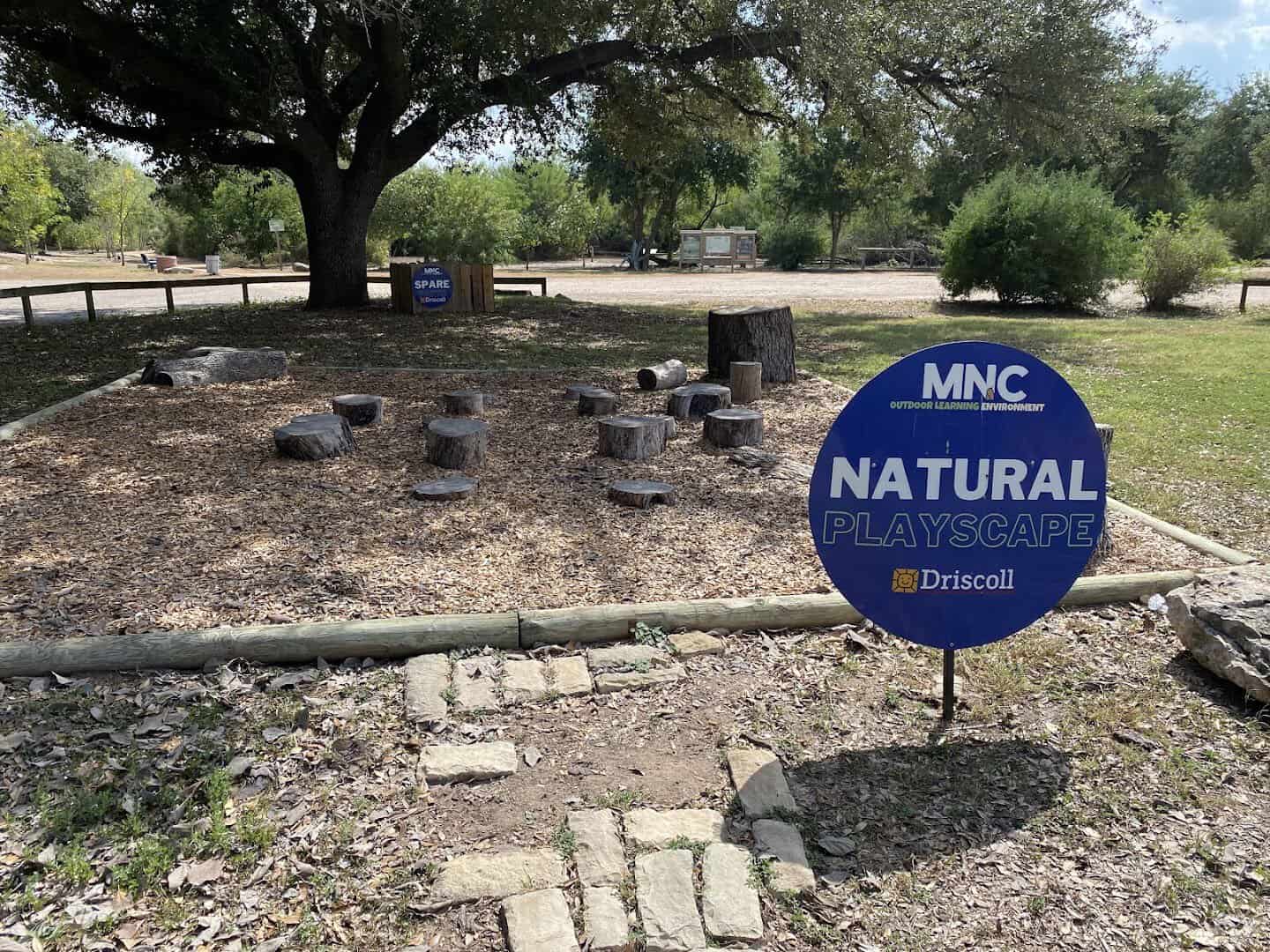 Tree-stump natural playscape in the outdoor learning area at the McAllen Nature Center