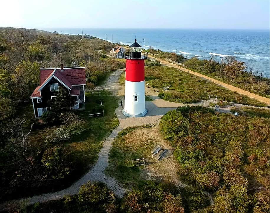 The red-and-white Nauset Light and keeper's house above the Atlantic shore on Cape Cod, Massachusetts