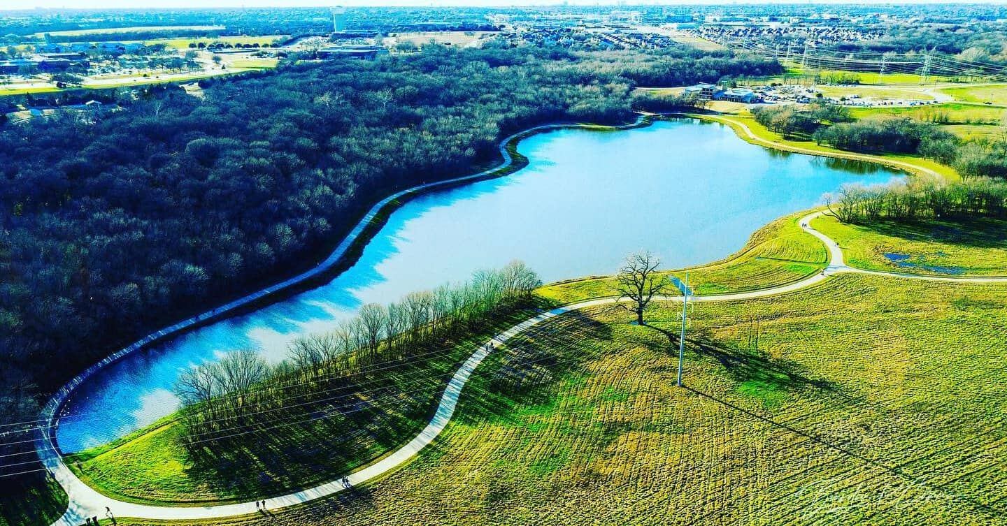 Aerial view of the paved loop trail around the pond at Oak Point Park and Nature Preserve in Plano