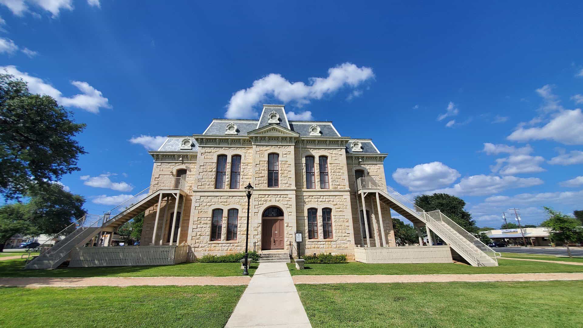 The 1885 Old Blanco County Courthouse under a blue sky in Blanco, Texas