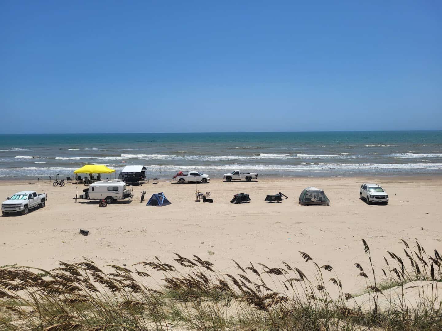 Vehicles and tents camped on the open beach at Padre Island National Seashore near Corpus Christi, Texas