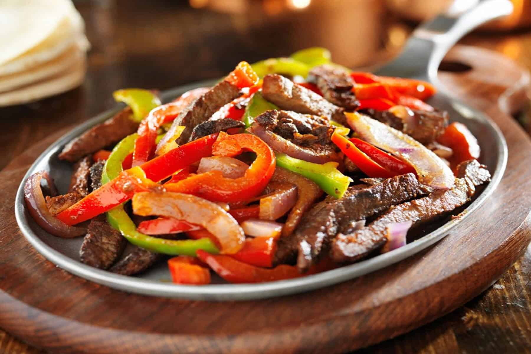 A sizzling plate of beef fajitas with peppers at Pancho's Mexican Buffet in Mesquite, Texas