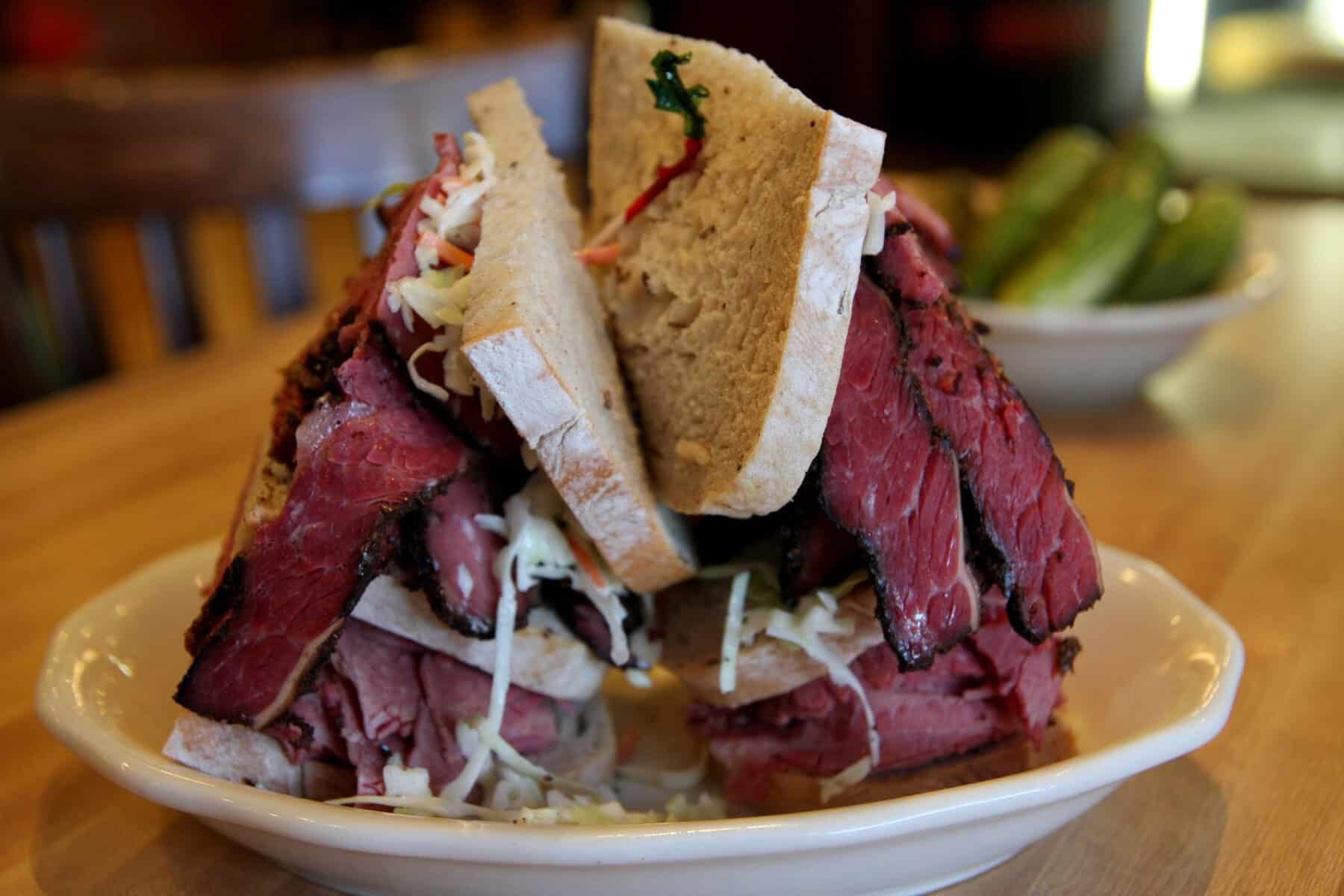 Towering pastrami sandwich on rye with coleslaw at Kenny & Ziggy's in Houston