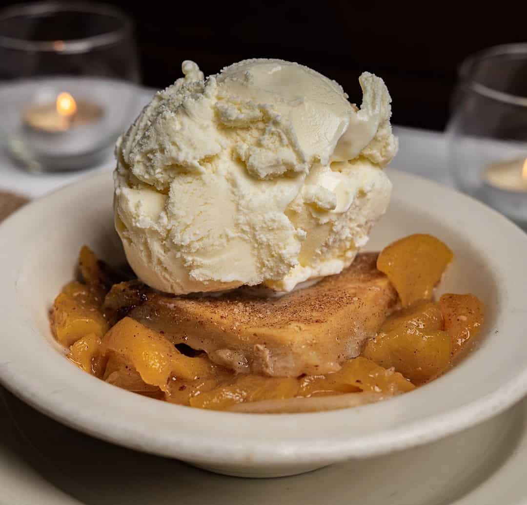 Warm peach cobbler with vanilla ice cream at Celebration Restaurant in Dallas
