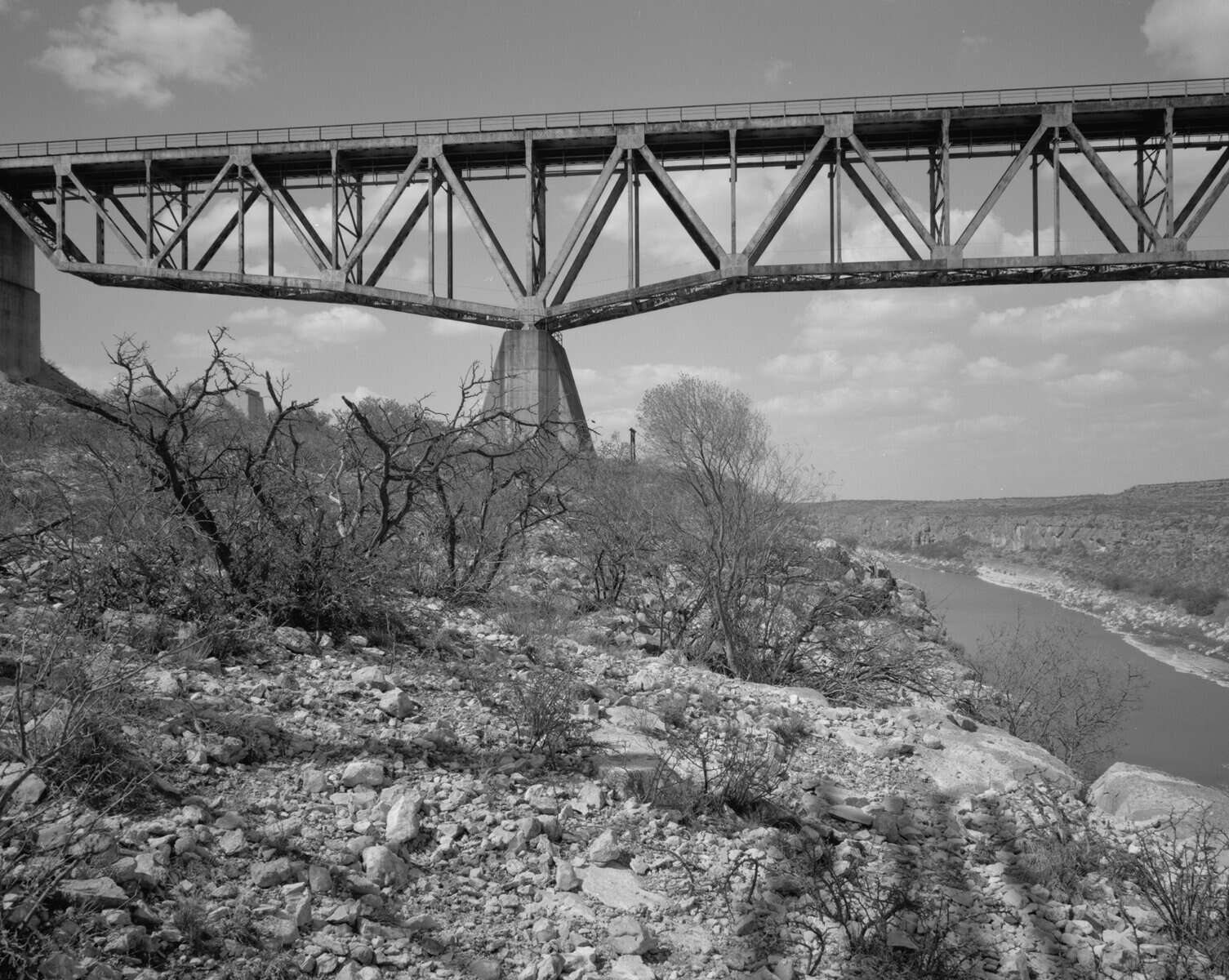 Archival side view of the railroad Pecos High Bridge truss spanning the Pecos River canyon