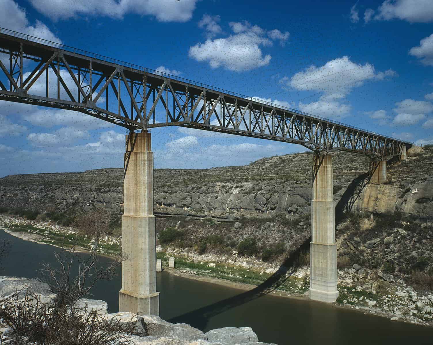 The 1944 railroad Pecos High Bridge on tall concrete piers above the Pecos River upstream of US 90