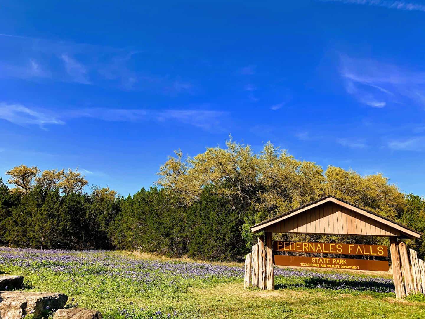 Pedernales Falls State Park entrance sign among Hill Country wildflowers