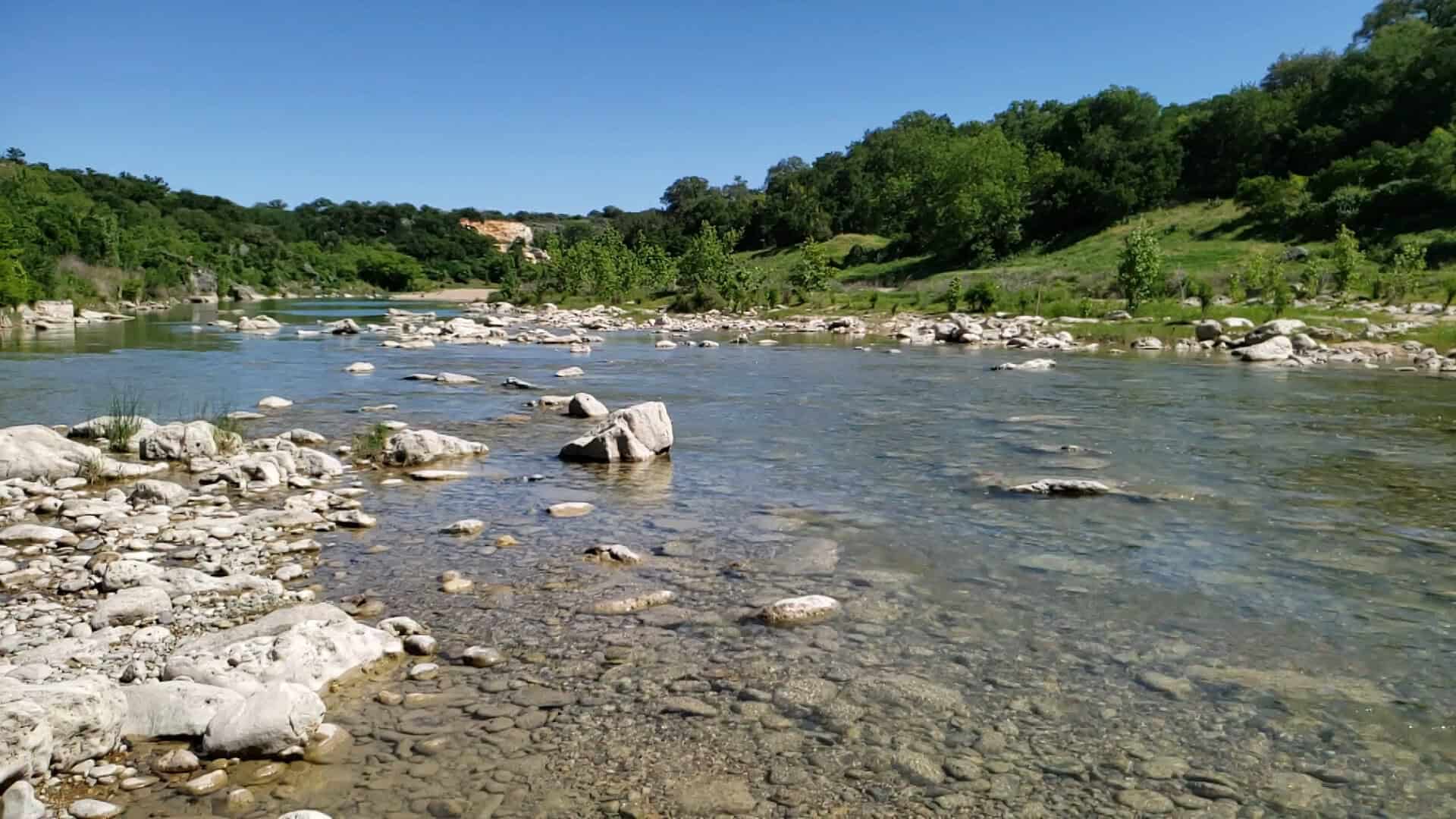 Clear shallow stretch of the Pedernales River over limestone at Milton Reimers Ranch Park