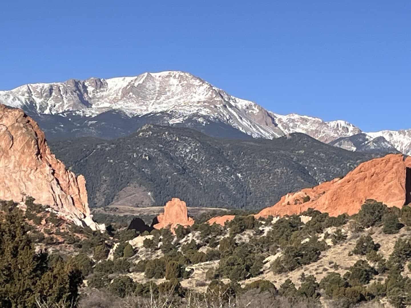Snow-capped Pikes Peak rising above red rocks near Colorado Springs, Colorado