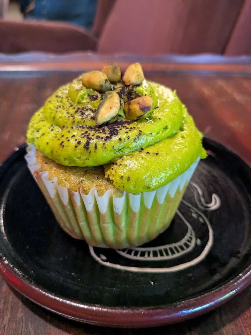 Green pistachio cupcake on a black plate at Triple Six Social in San Marcos, Texas