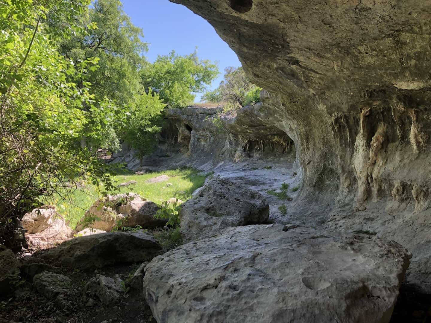 Pocketed limestone bluff above the creek at Tonkawa Falls City Park in Crawford, Texas