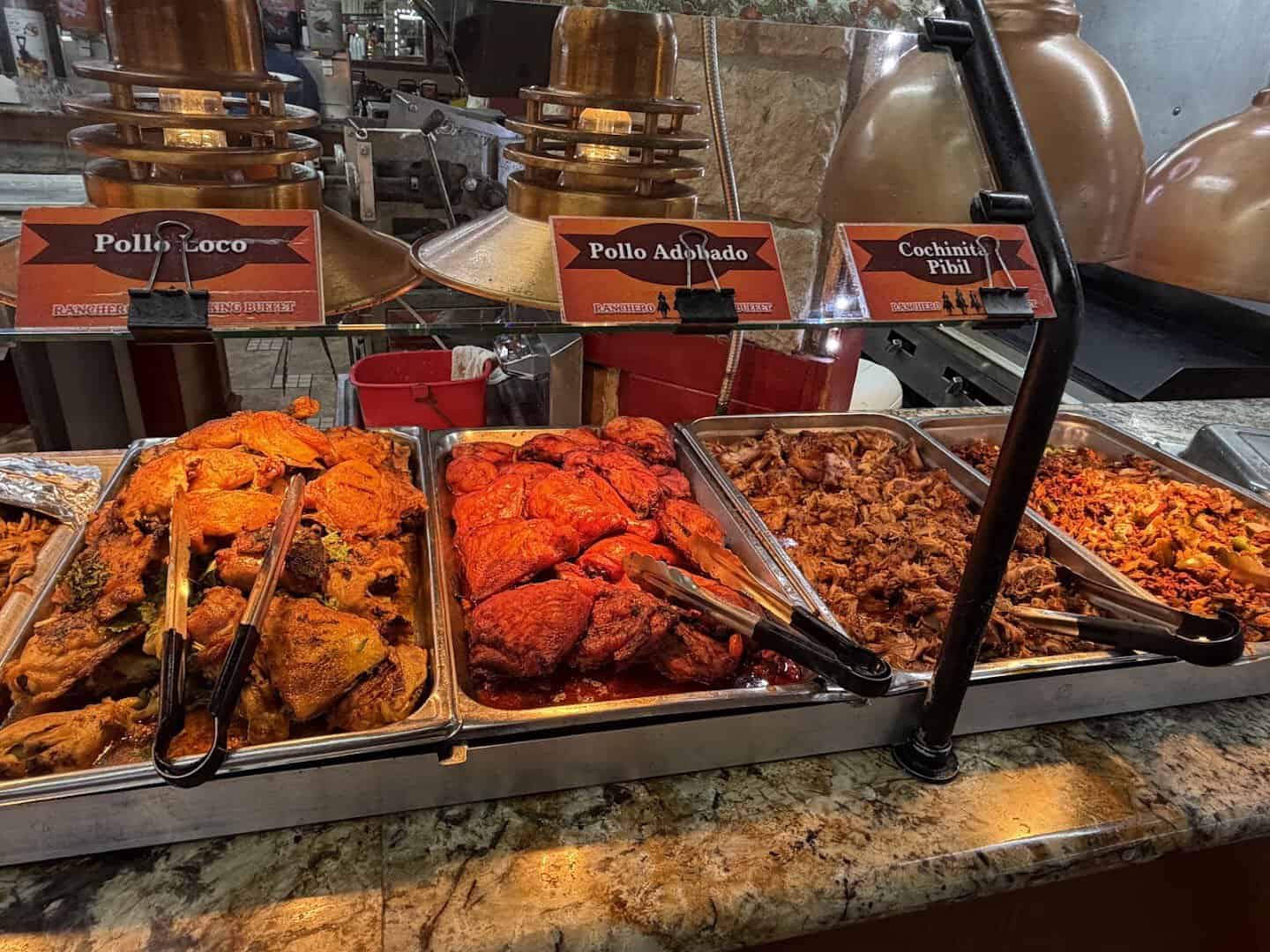 Buffet trays of pollo loco, pollo adobado and cochinita pibil at Ranchero King Buffet in Houston