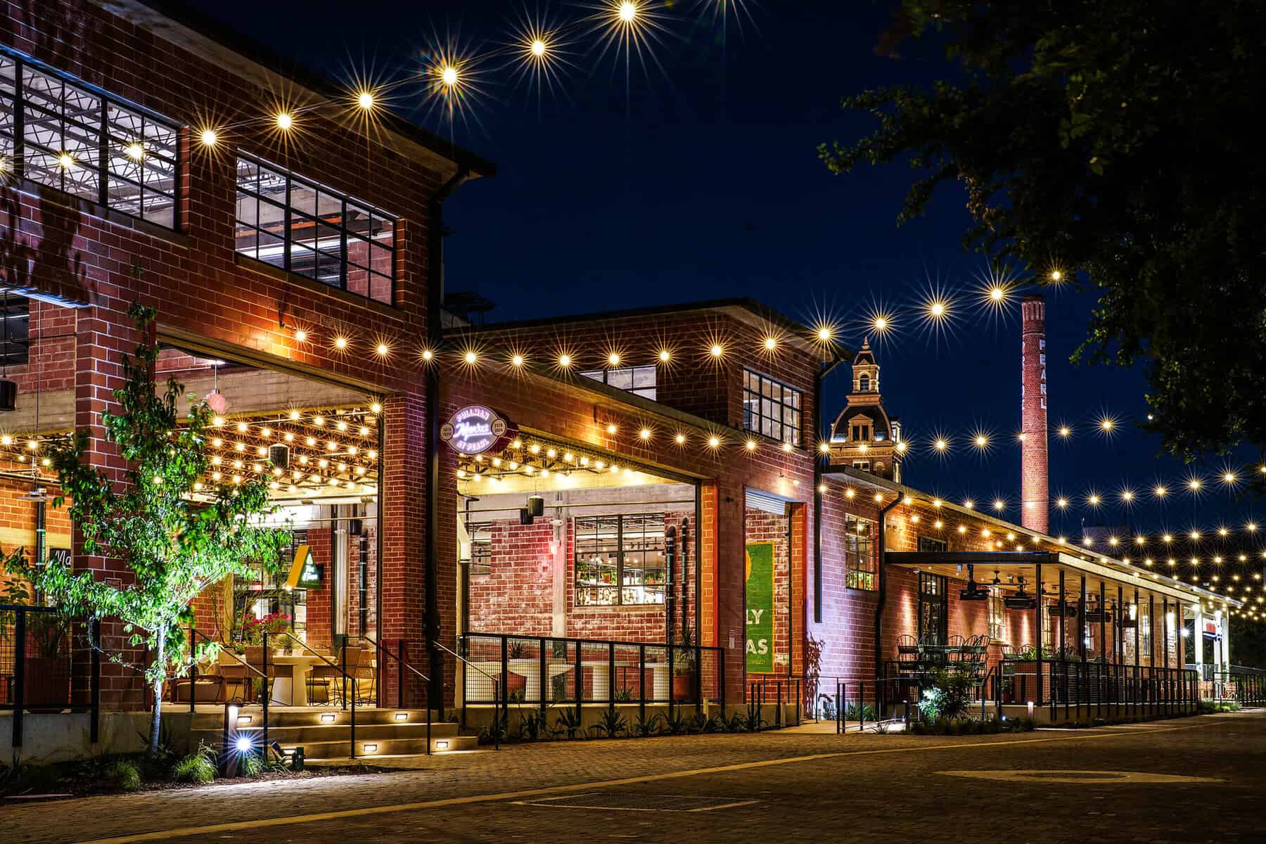 The exterior of Pullman Market lit up at night in San Antonio's Pearl District
