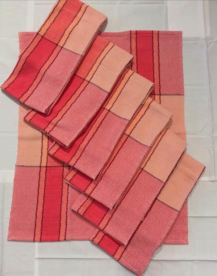 Stacks of folded coral fabric fat quarters at The Quilted Skein in La Grange, Texas