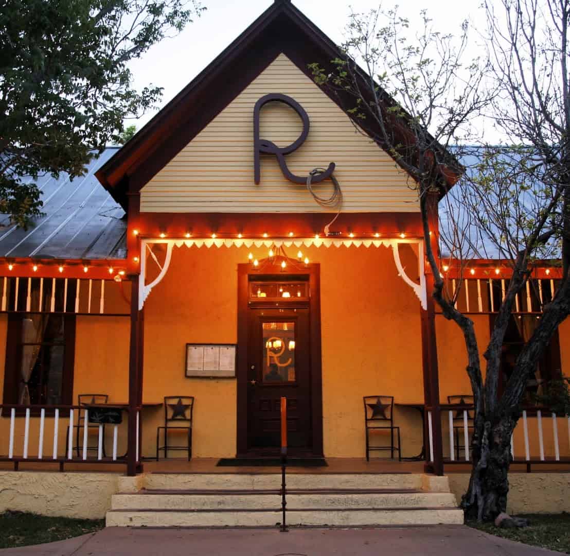 The Reata restaurant building lit up at dusk in Alpine, Texas