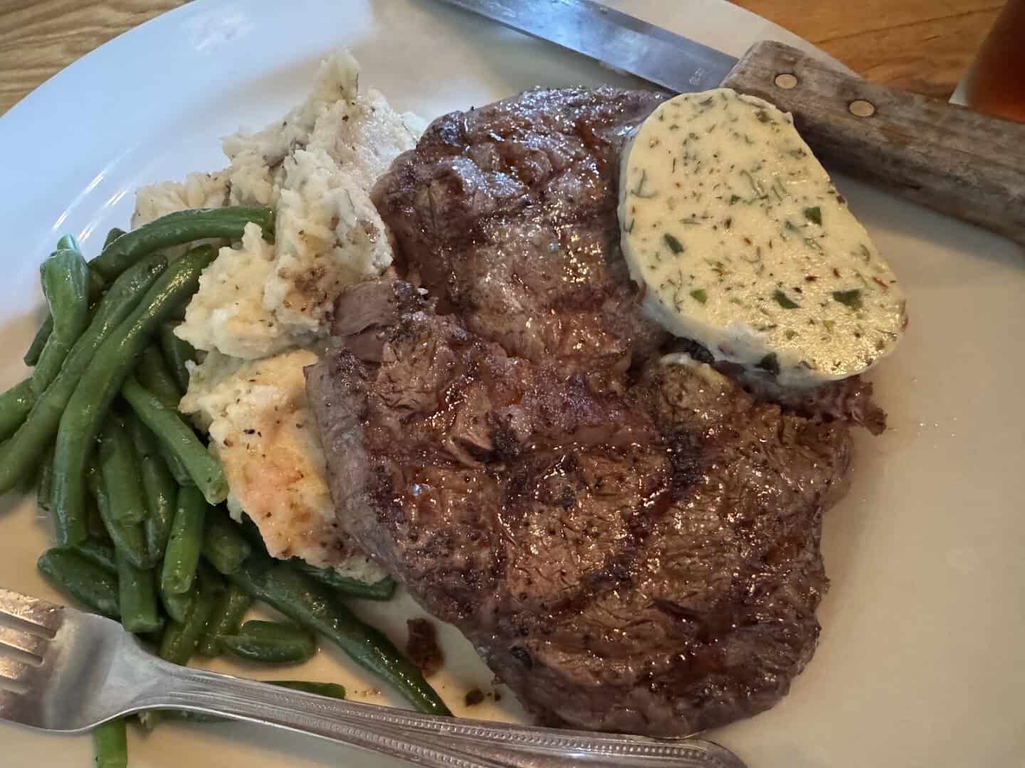 Charbroiled ribeye with cook's butter, green beans and mashed potatoes at Reata in Alpine, Texas