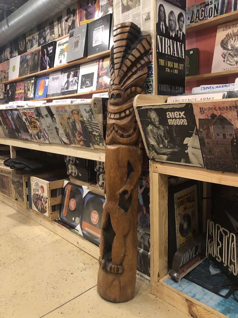 Record shelf with a carved tiki and Nirvana albums at Sigs Lagoon in Houston