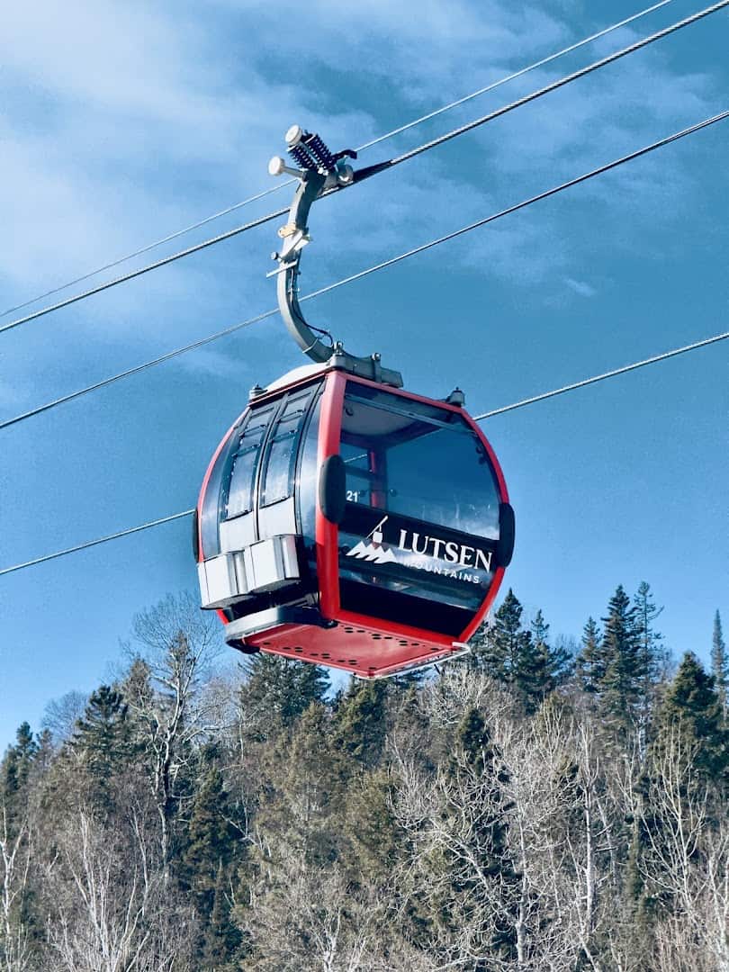 A red Lutsen Mountains gondola cabin rising over snow-covered pines, Lutsen, Minnesota