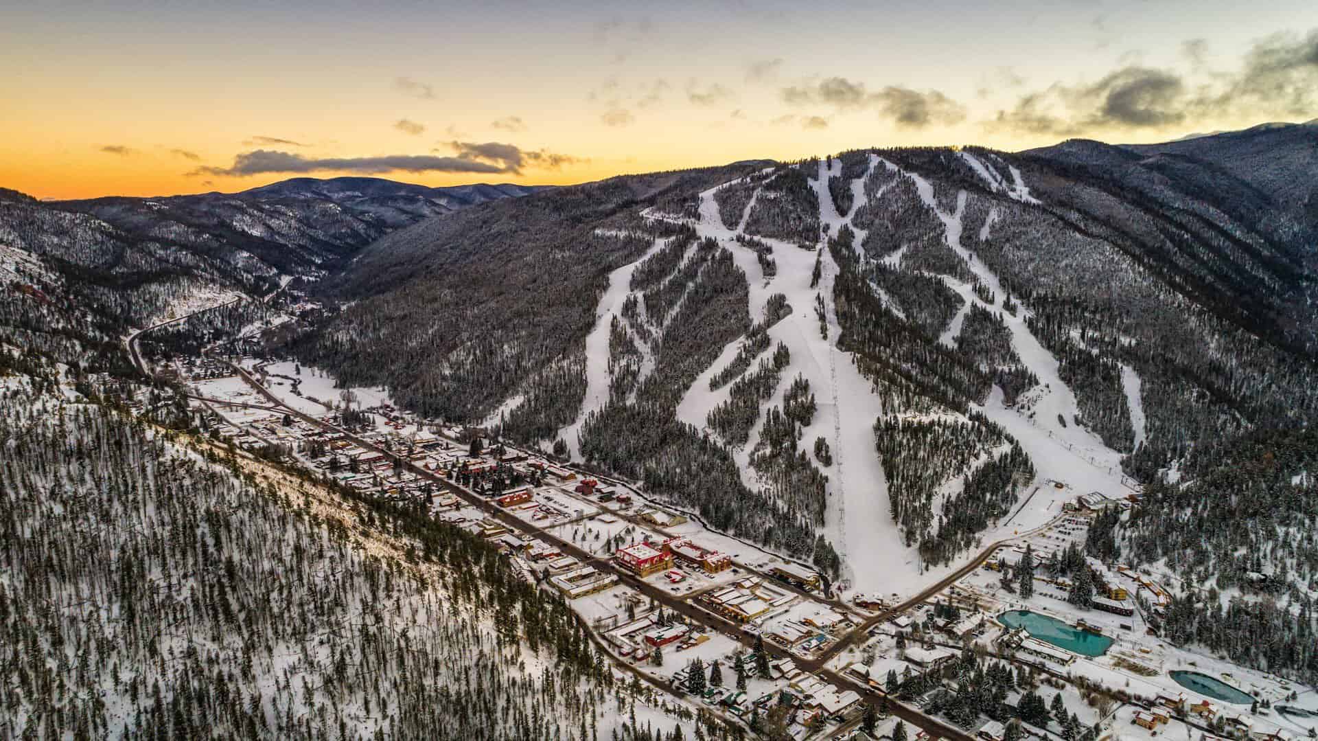 Aerial view of snow-covered Red River town and its ski runs at sunset, Red River, New Mexico
