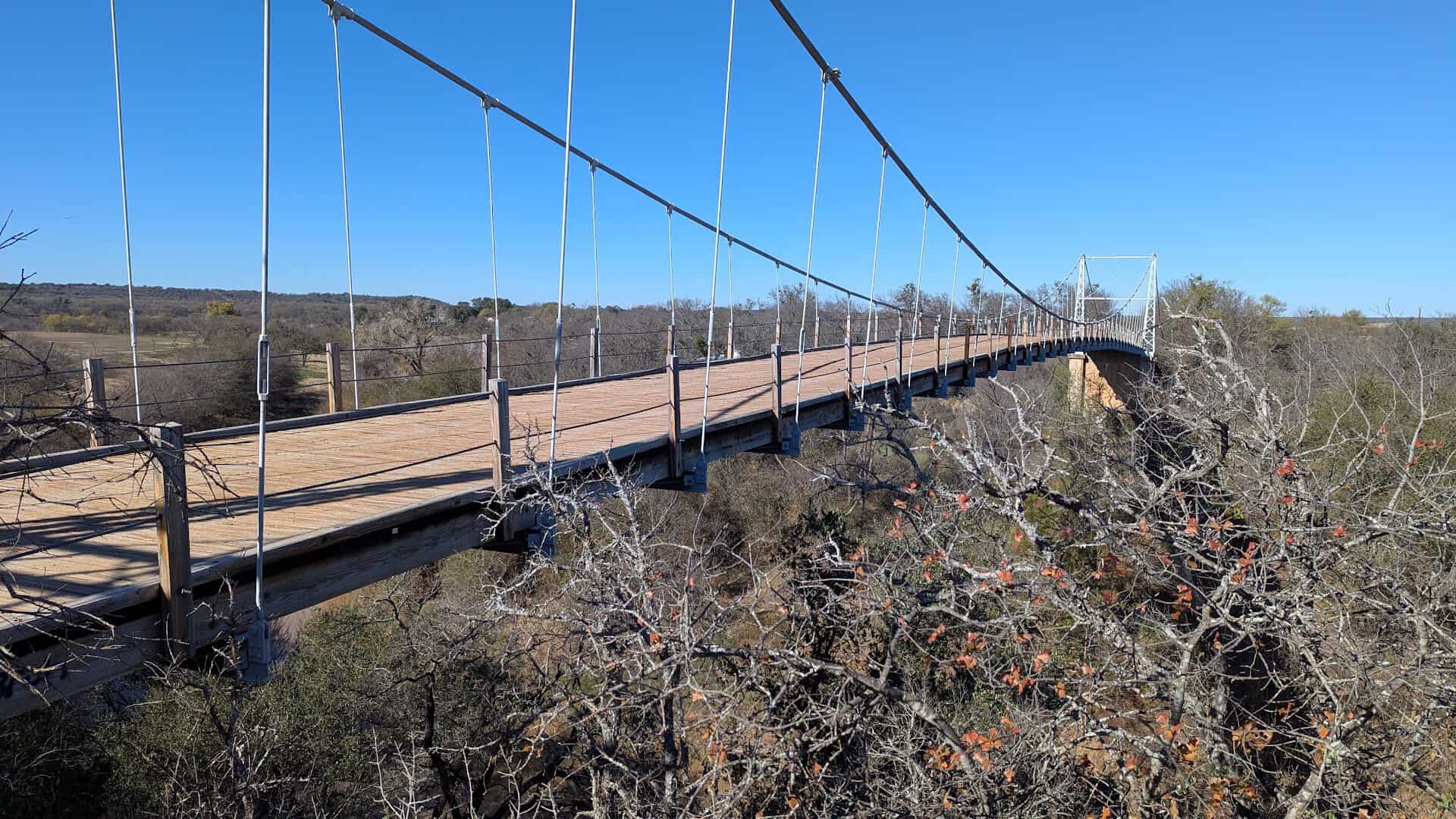 The wooden roadway and steel towers of the Regency Suspension Bridge in Texas