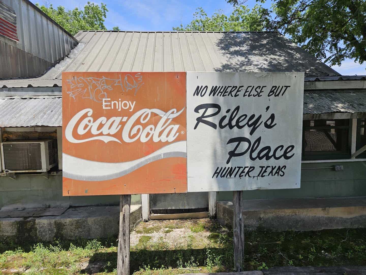 Vintage Coca-Cola sign reading Riley's Place, Hunter, Texas outside Riley's Tavern