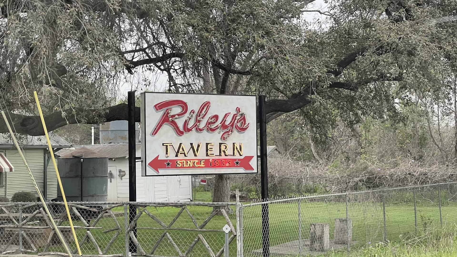 The roadside Riley's Tavern sign on FM 1102 in Hunter, Texas