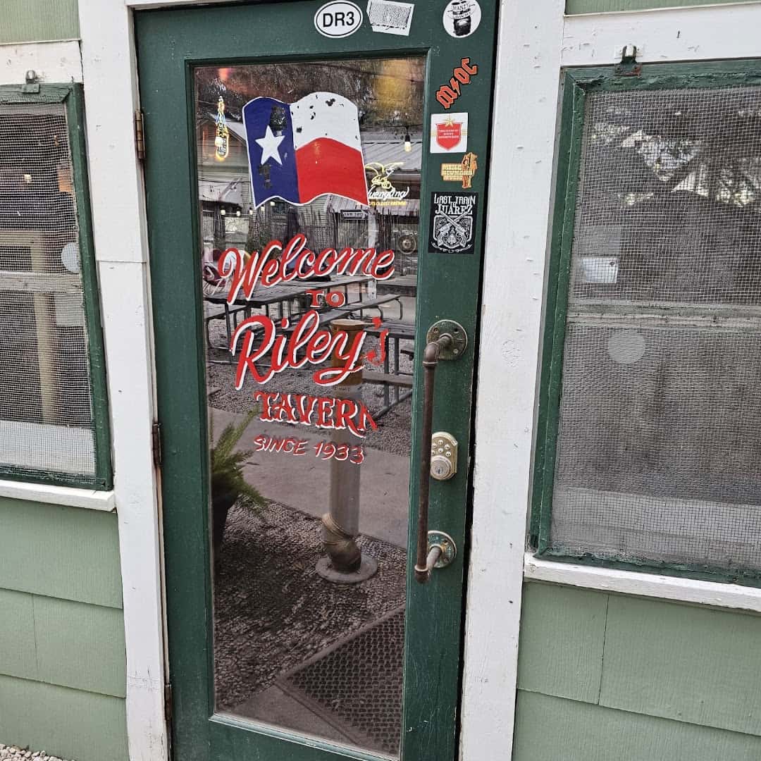 Welcome to Riley's Tavern entrance door with a Texas flag at Riley's Tavern in Hunter