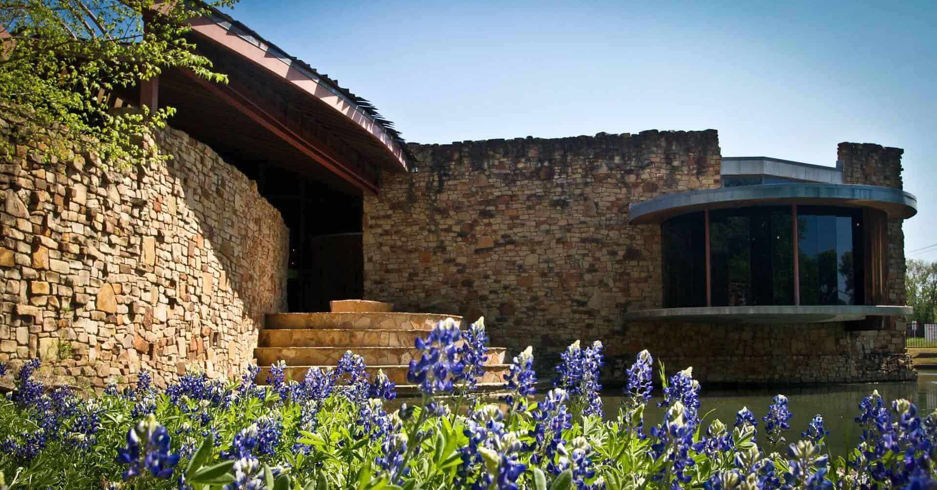 The limestone River Legacy Nature Center with bluebonnets in Arlington