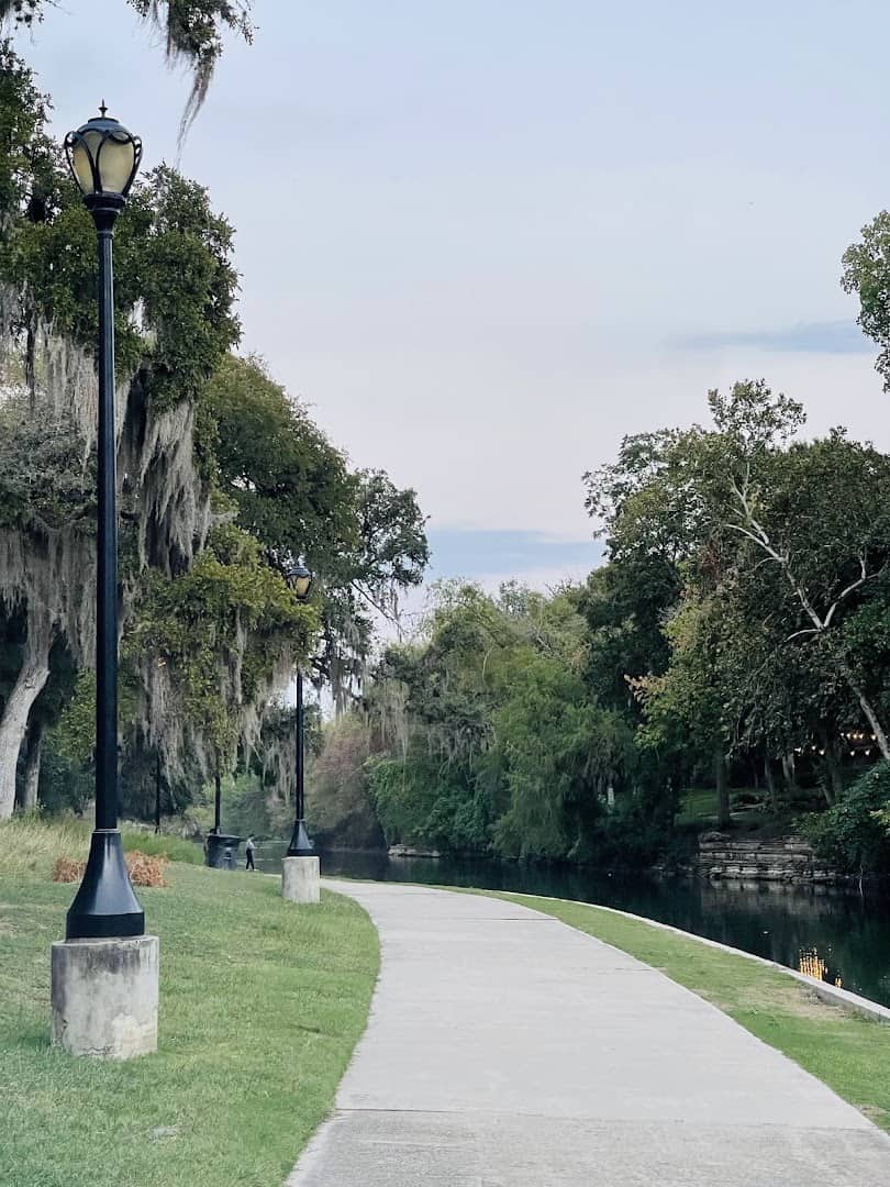 Paved riverside walking path and lamp post at Hinman Island Park in New Braunfels