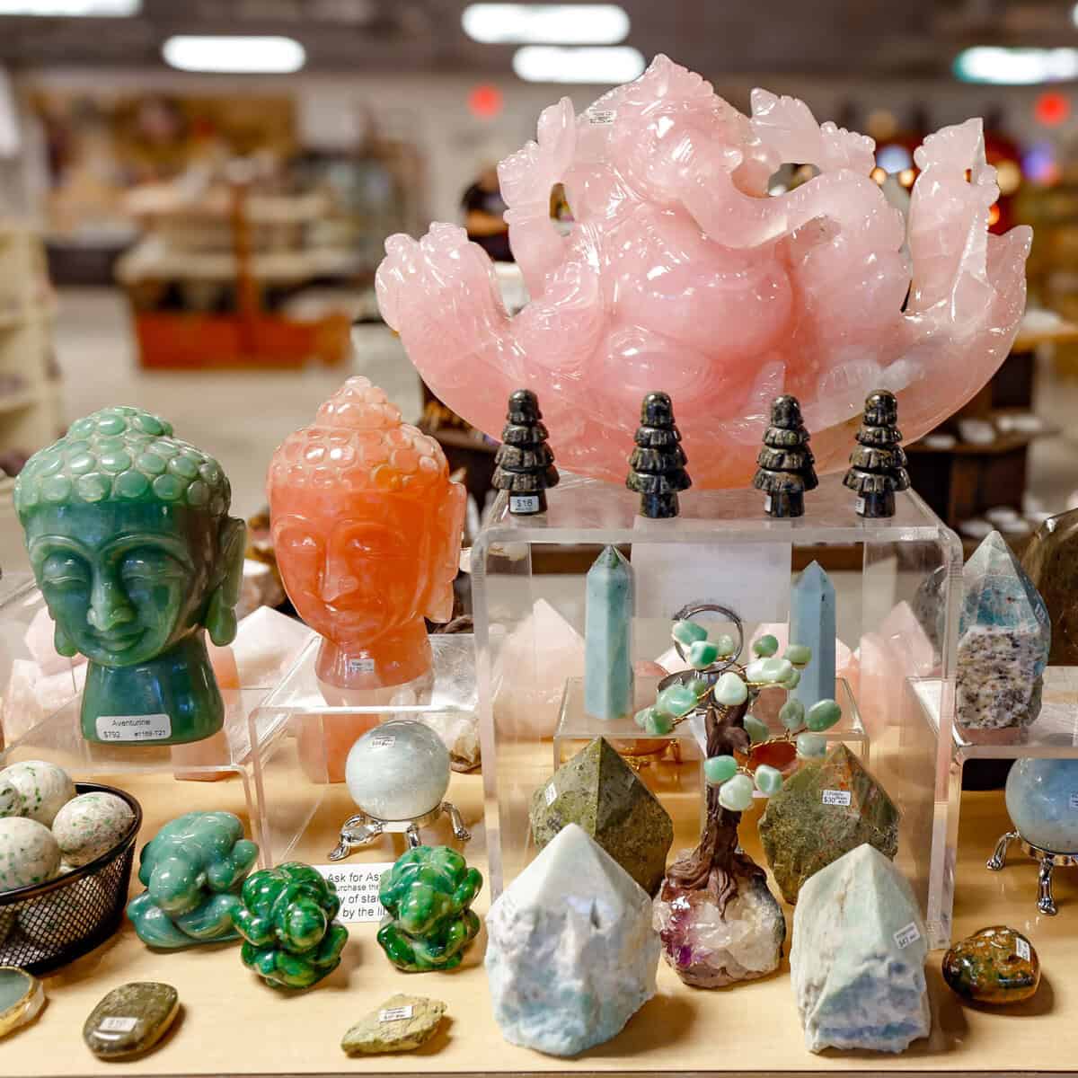 Rose quartz Buddha heads and crystal carvings on display at Nature's Treasures in Austin