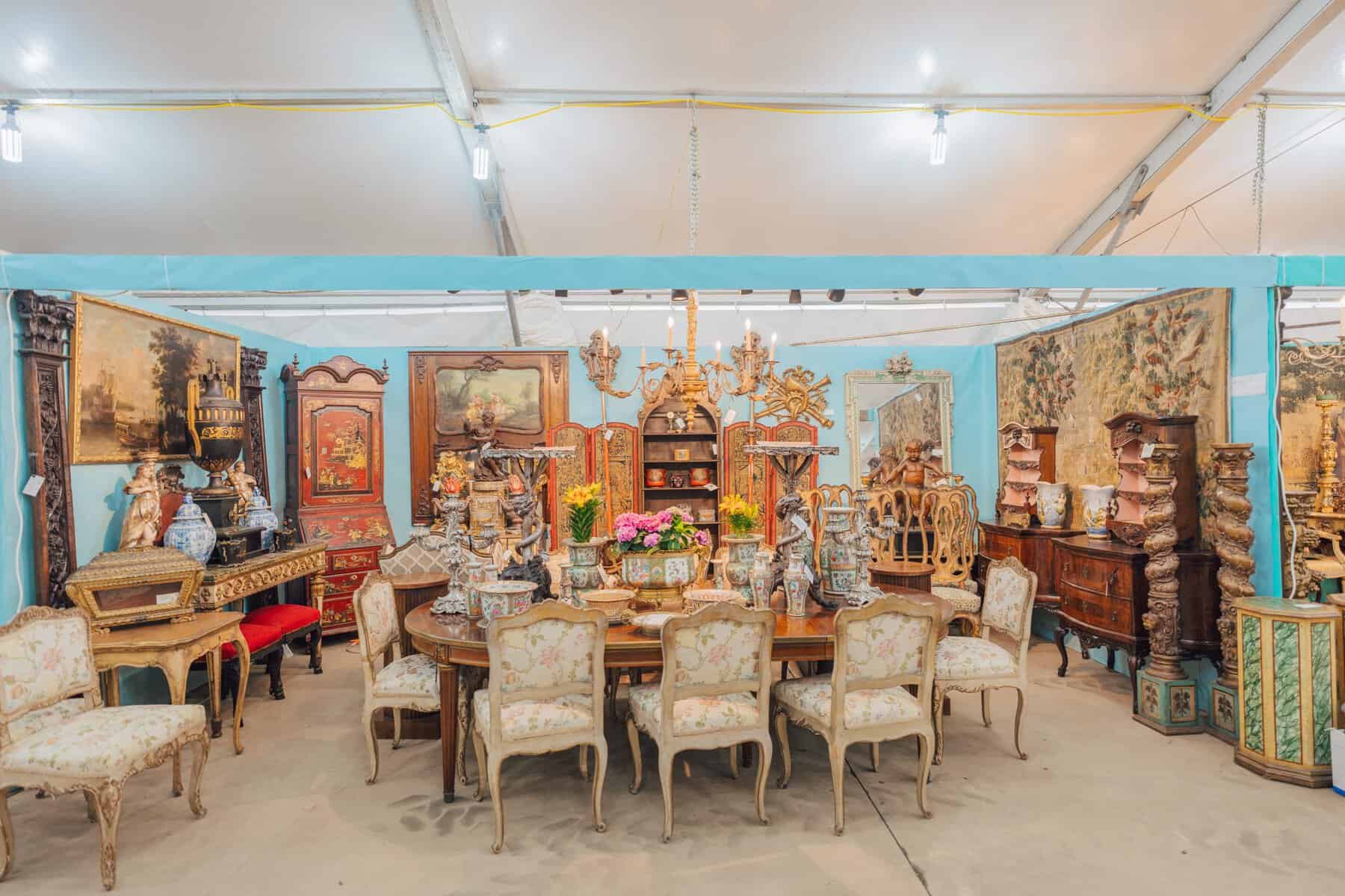 Styled antique dining furniture in a booth at the Original Round Top Antiques Fair
