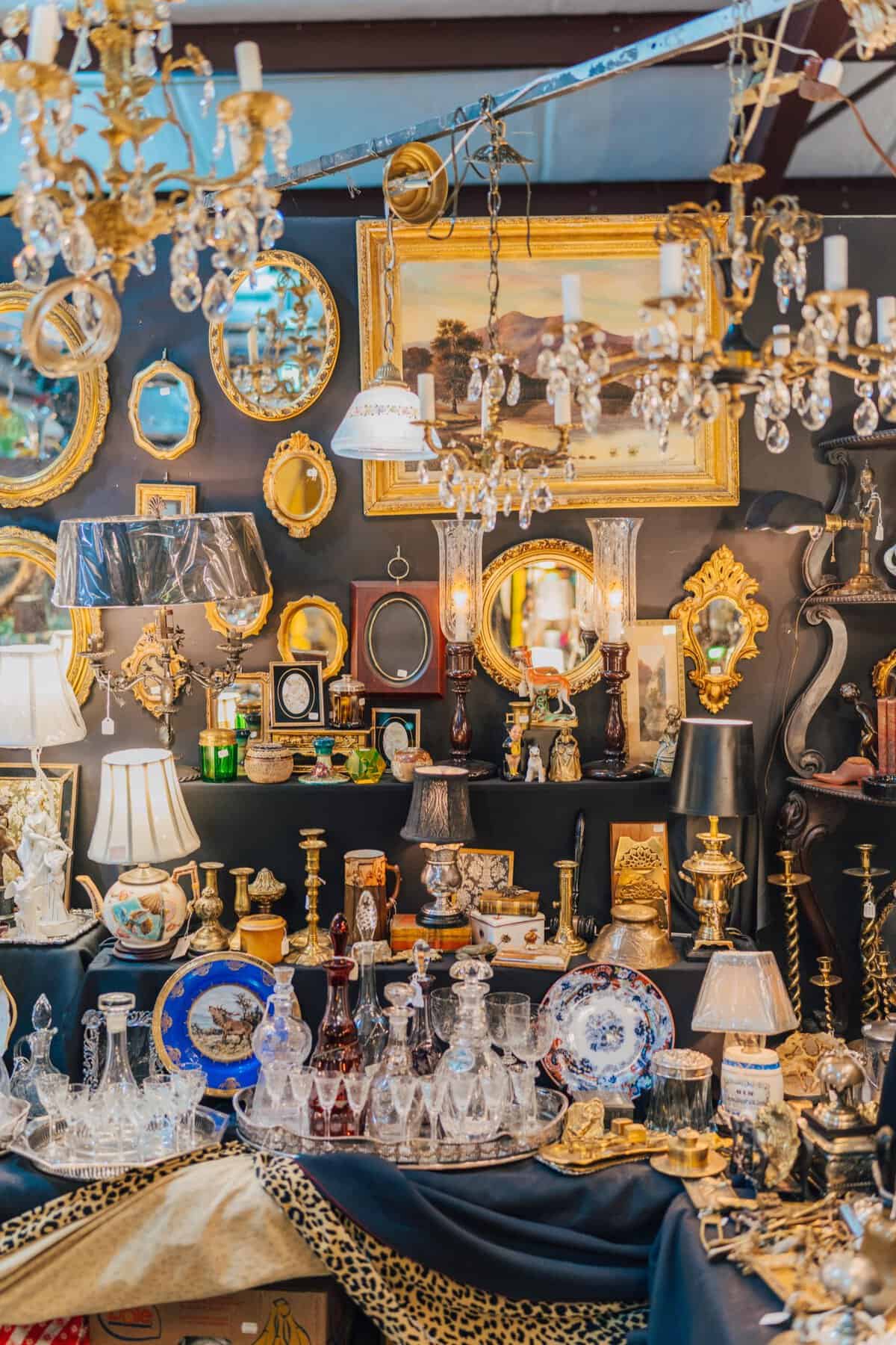A packed wall of antique mirrors, plates and lamps at a Round Top booth