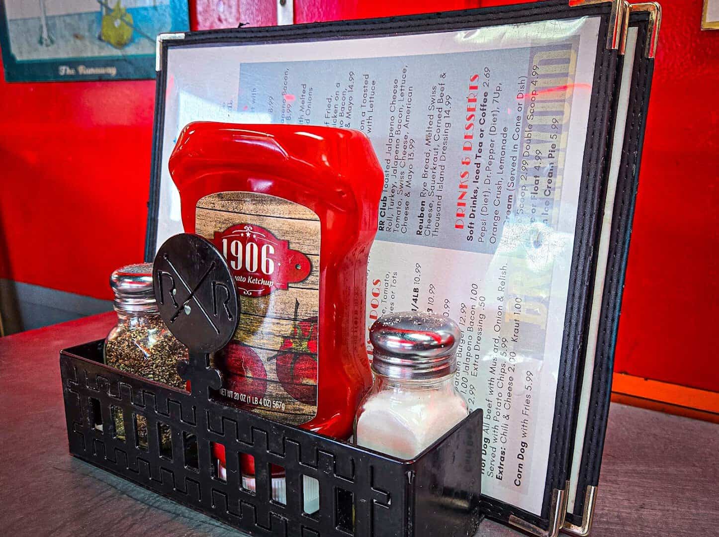 Menu and condiments on a red diner table inside the Runaway Train Cafe