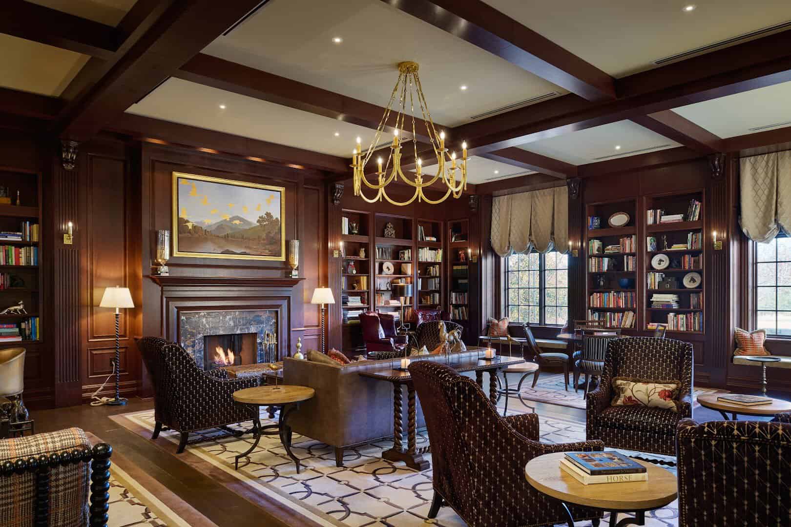 Wood-paneled library lounge with a fireplace at Salamander Middleburg, Virginia