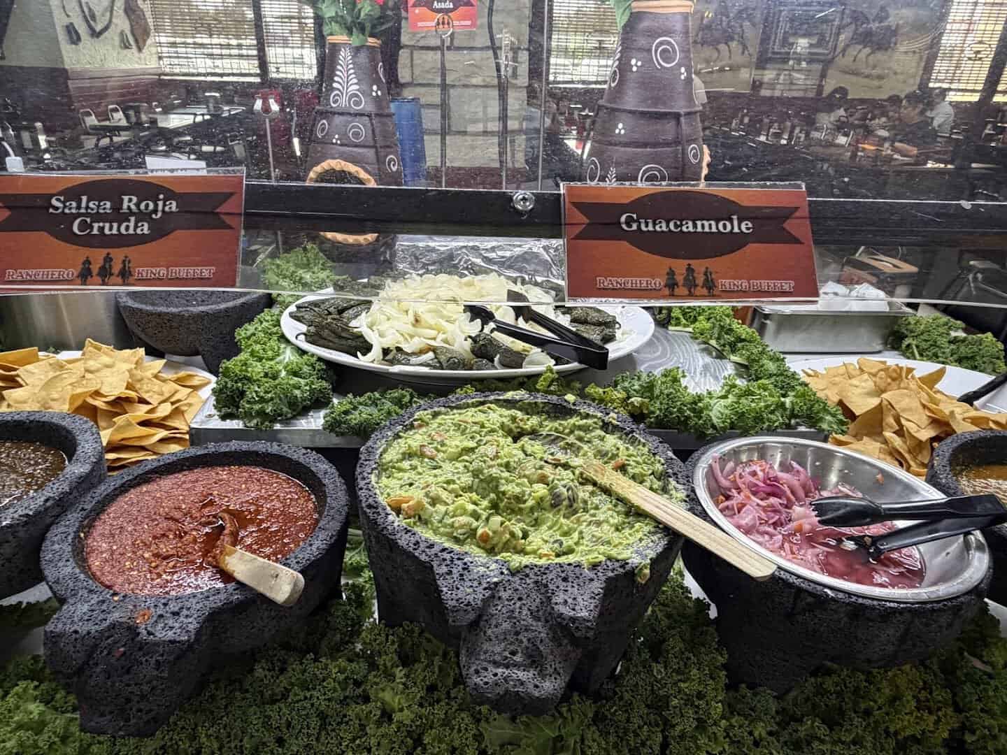 Salsa bar with molcajetes of salsa verde, salsa roja and guacamole at Ranchero King Buffet in Houston