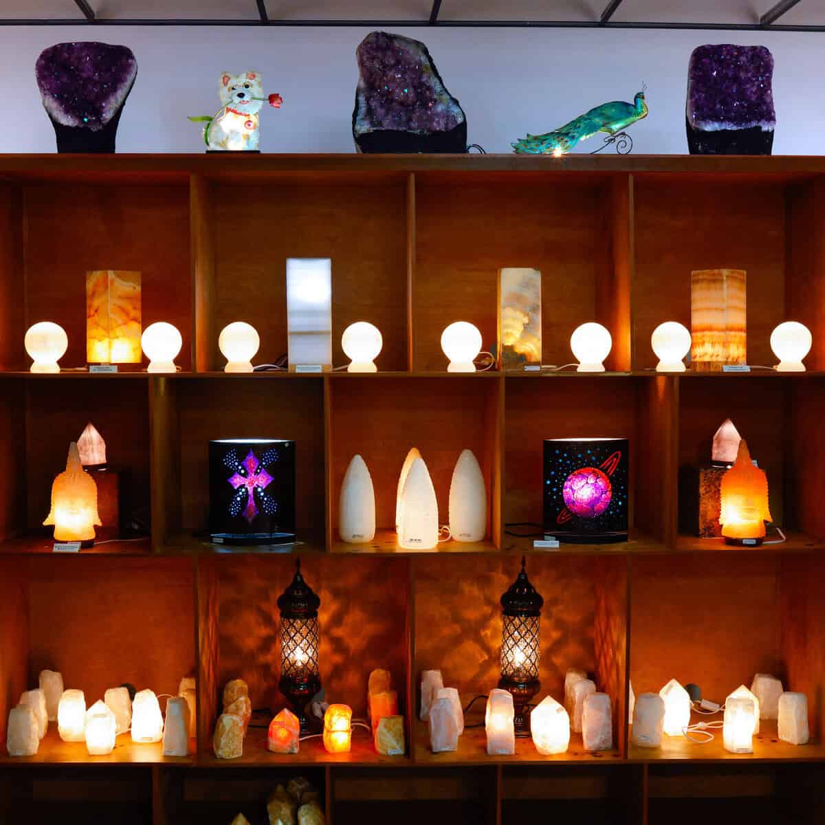 Shelves of glowing salt lamps and selenite lamps at Nature's Treasures in Austin