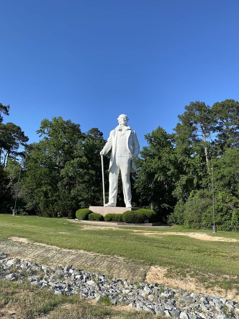 The Sam Houston statue rising above the lawn and pines in Huntsville