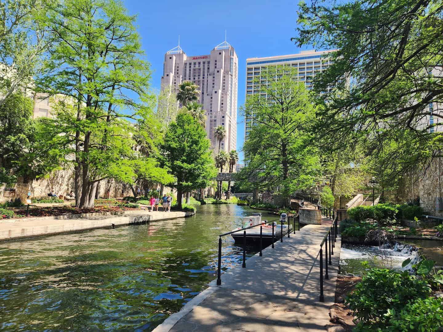 The cypress-lined San Antonio River Walk with downtown towers, San Antonio, Texas