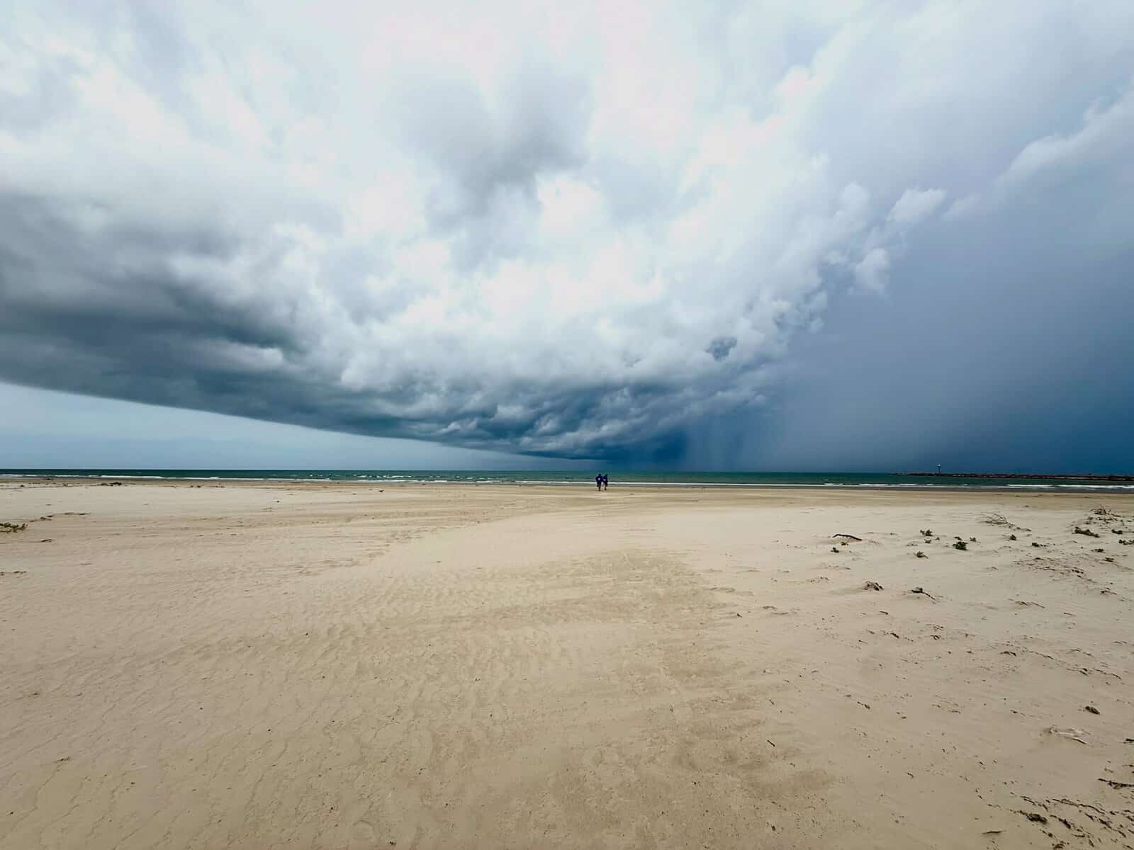 Undeveloped beach and a distant jetty on San Jose Island near Port Aransas, Texas, under a storm sky