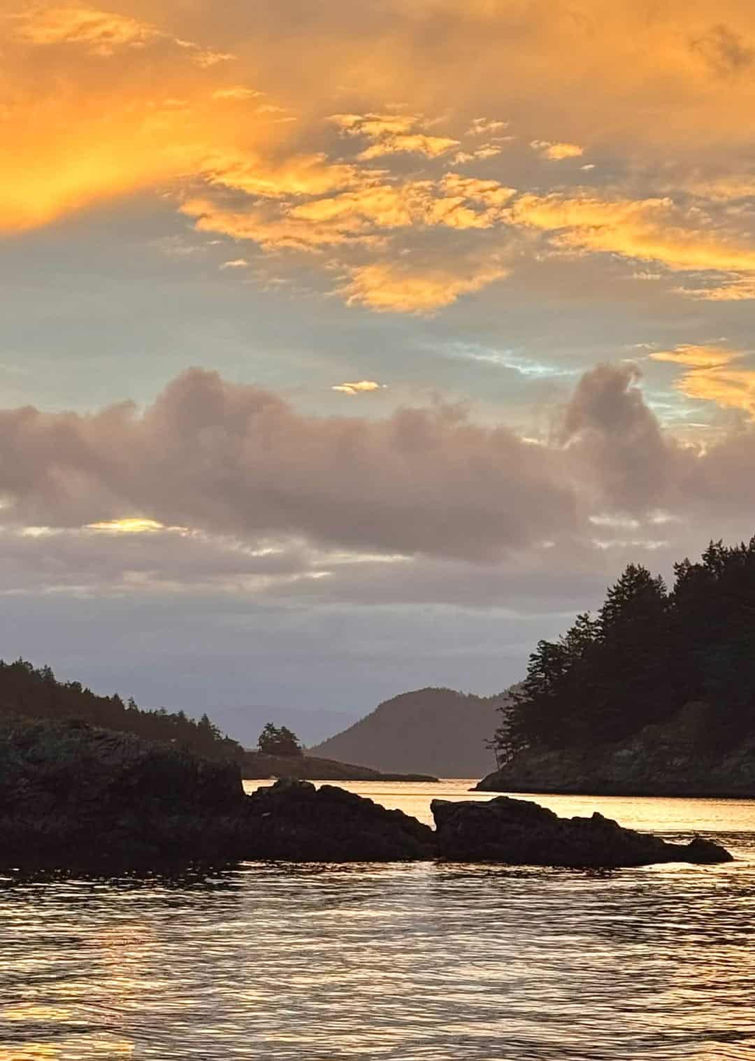 Sunset over the water and forested shorelines of the San Juan Islands, Washington