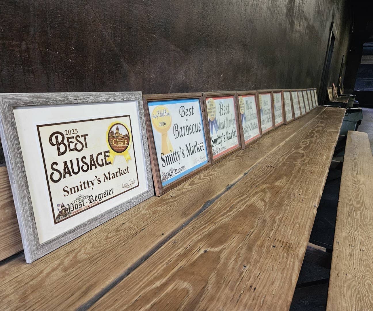 Framed Best Sausage and Best Barbecue awards lined up inside Smitty's Market in Lockhart, Texas