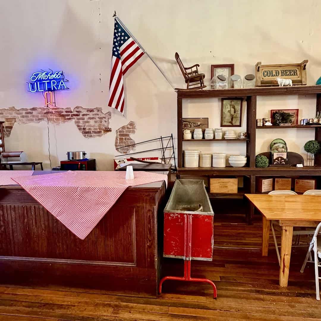 Long communal dining tables and a Texas flag inside Smitty's Market in Lockhart, Texas