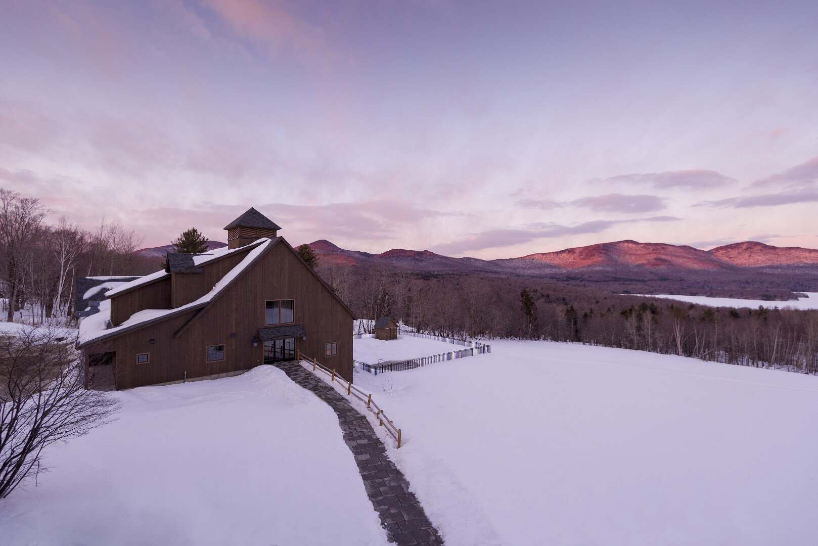 Snow-covered lodge above the frozen reservoir at sunset, Mountain Top Resort, Chittenden, Vermont