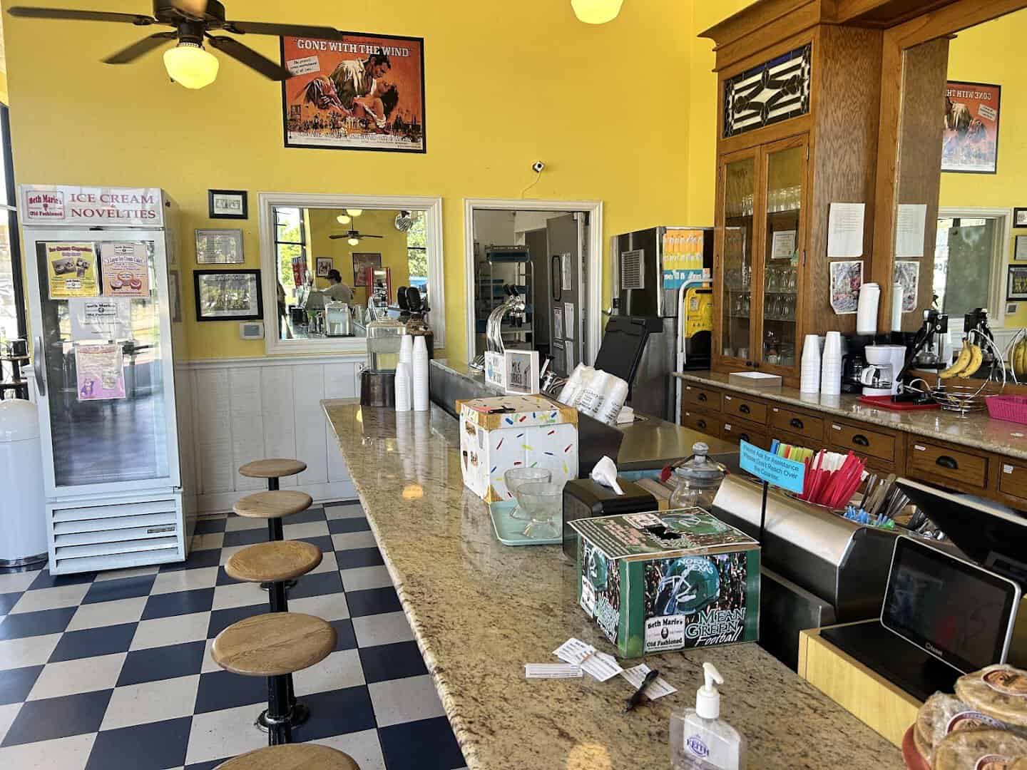 Counter stools and checkerboard floor at Beth Marie's Unicorn Lake parlor in Denton