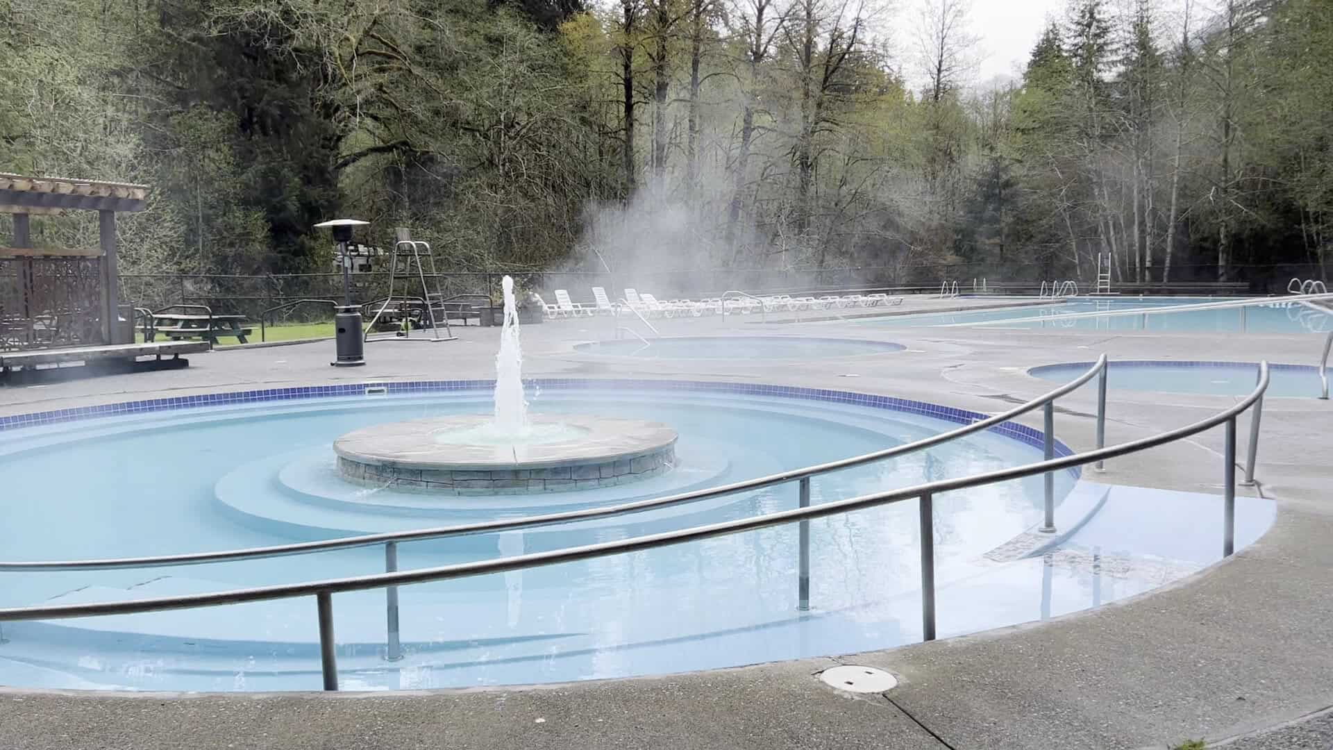 Round mineral soaking pools with a central fountain in the forest at Sol Duc Hot Springs Resort, Washington